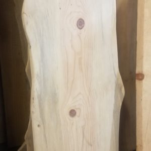 a blue stained pine urban wood live edge slab showing the bottom half of the slab and character knots